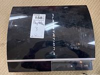 Top view showing black glossy finish with visible scuffs and PlayStation 3 text.