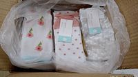 Top down view of box containing folded pairs of socks in various patterns including polka dots and flowers.