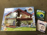 Bluey's Family Home packaged playset including Bluey figure and two Pop It bubble popping games in original packaging boxes, viewed from the front