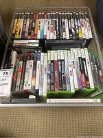 Full lot view showing multiple Xbox 360 and PS3 game cases stacked, visible titles include NHL 10, NBA Live, FIFA, NBA 2K17, Forza Motorsport, and more.