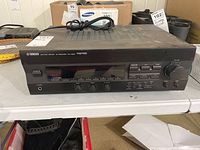 Front view of Yamaha RX-V293 AV receiver showing main controls, headphone jack, and power button.