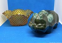 Amber diamond-cut and etched glass bowl with ruffled edge and vintage McMaster pottery piggy bank in green drip glaze shaped like a pig