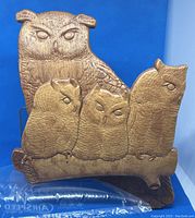 Front view of the wooden carved owl wall decor showing five owls on a branch with carved details.