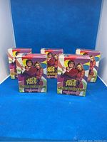 Five sealed packages of Austin Powers collectible card game cards from 1995 with colorful packaging featuring characters from the series, standing on a blue backdrop.