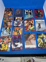Group photo showing 14 glossy Marvel superhero and supervillain trading cards from 1994 Fleer Ultra set laid out in rows on blue background.