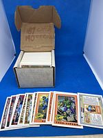 Open box of GI Joe trading cards with cards fanned out in front showing character illustrations and details.