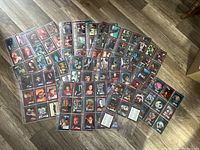 Photo displaying numerous collectible Star Trek and Star Trek: The Next Generation cards arranged in rows on a wooden floor, all sleeved.
