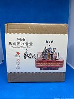 Photo of the sealed Tonecheer DIY Music Box kit in original packaging showing the box with circus-themed music box illustration.