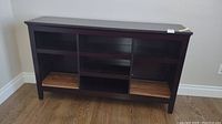Front view of the wooden buffet shelf unit showing three compartments and base legs.