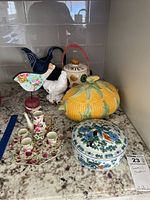 Overview of the lot showing miniature tea set, corn-shaped dish, bird figurines, and 'COMBES' container.