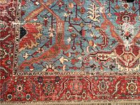 Close-up of the rug pattern showing the blue, red, beige, and brown colors with geometric and floral motifs.
