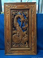 Full front view of carved wood dragon wall art framed piece