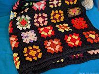 Crochet blanket folded showing different angles and colorful granny squares on black background.