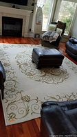 Photo showing full view of area rug in a living room with a fireplace, surrounded by furniture.