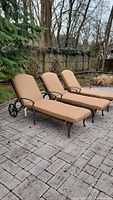 Three chaise lounge chairs on stone paver patio, showing overall set