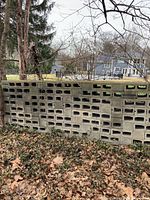 Stack of concrete cinderblocks outdoors showing weathered surfaces and hollow cores.