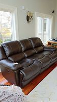 Front perspective view of three-seat leather recliner sofa showing overall shape and seating configuration