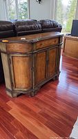Front view of the wood server showing decorative painting, trim, and storage door layout with drawer.