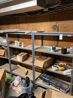 Full view of two metal shelving units with various items on shelves and visible adjustable wood shelves.