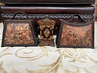 Front view of three decorative items: two faux leather embossed purses and a decorative container