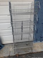 Front view of the 6 tier metal wire basket cart showing the 6 open baskets with vertical metal wire supports and caster wheels at the base.