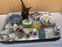 Overview of miscellaneous small collectibles including figurines, salt and pepper shakers, trinket box, and small bowls