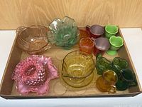 Wide view of all 17 pieces in the vintage glass lot showing colors and types.