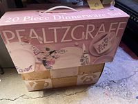 Box of a 20-piece Pfaltzgraff Cape May dinnerware set showing floral design on plates and bowls with pink and purple flowers.