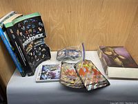 Photo of Pokémon sticker book, Pokédex book, DS game case, and some Pokémon trading cards