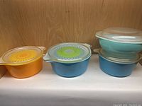 Overview showing four Pyrex bowls with lids: two printed and two solid colors