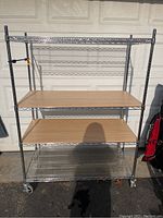 Full front view of the metal rolling shelving cart showing wooden and wire shelving arrangement.