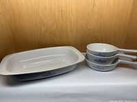 Large rectangular roaster with blue cornflower design inside wooden cabinet