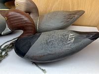 Close-up of all three wooden duck decoys showing paint detail and lead keels on one decoy.