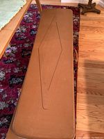 Top view of rectangular brown gun case showing exterior stitching pattern and double handles