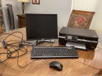 All four items on table: Dell monitor with cables, HP printer, ASUS keyboard and mouse visible