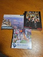 Photo of the three puzzle boxes: Grand Canyon, Harry Potter, and dog street scene by Karen Burke