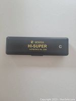 Closed view of the Miwha Hi-Super harmonica case showing gold lettering and key indication C, model No. 2000.