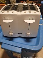 Front view of Betty Crocker white 4-slice toaster showing two levers, two browning dials, and brand logo.