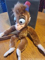 Front view of vintage Abu stuffed animal showing entire body, plush brown fur, plastic face with detailed molded features, and fez hat.