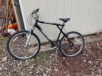 Side full view of black GT Aggressor mountain bike showing frame, tires, seat and handlebar.