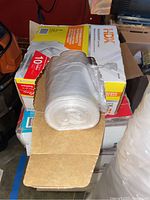 Boxes stacked with one box open showing rolled white plastic trash bags