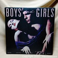 Front cover of Bryan Ferry Boys and Girls album showing a man and woman with title text 'Boys and Girls'