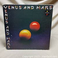 Front cover of Venus and Mars vinyl record album by Paul McCartney and Wings with planetary artwork and title text.