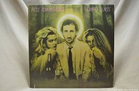 Front cover of Pete Townshend Empty Glass vinyl album showing Townshend with two women and halo effect.