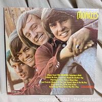 Front cover of The Monkees 'Meet The Monkees' vinyl record showing smiling band members and visible track list.