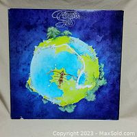 Front cover of Yes 'Fragile' vinyl record album showing the artistic depiction of a small planet or island with a sailing ship.