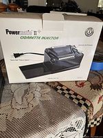 Powermatic II+ cigarette injector machine in white original box showing product image and labeling.