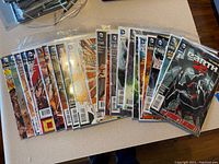 Full spread of 15 DC Comics Earth 2 issues laid out, individually bagged.