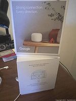Front and back of one Google Nest Wi-Fi Booster box showing product image and feature descriptions about strong connection and Wi-Fi performance.