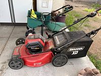 Side view of red Snapper XD mower showing 21" steel deck, battery pack and grass catcher